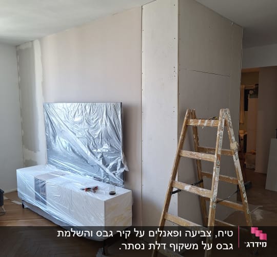 עבודת גבס עם סולם ורהיטים מכוסים בניילון